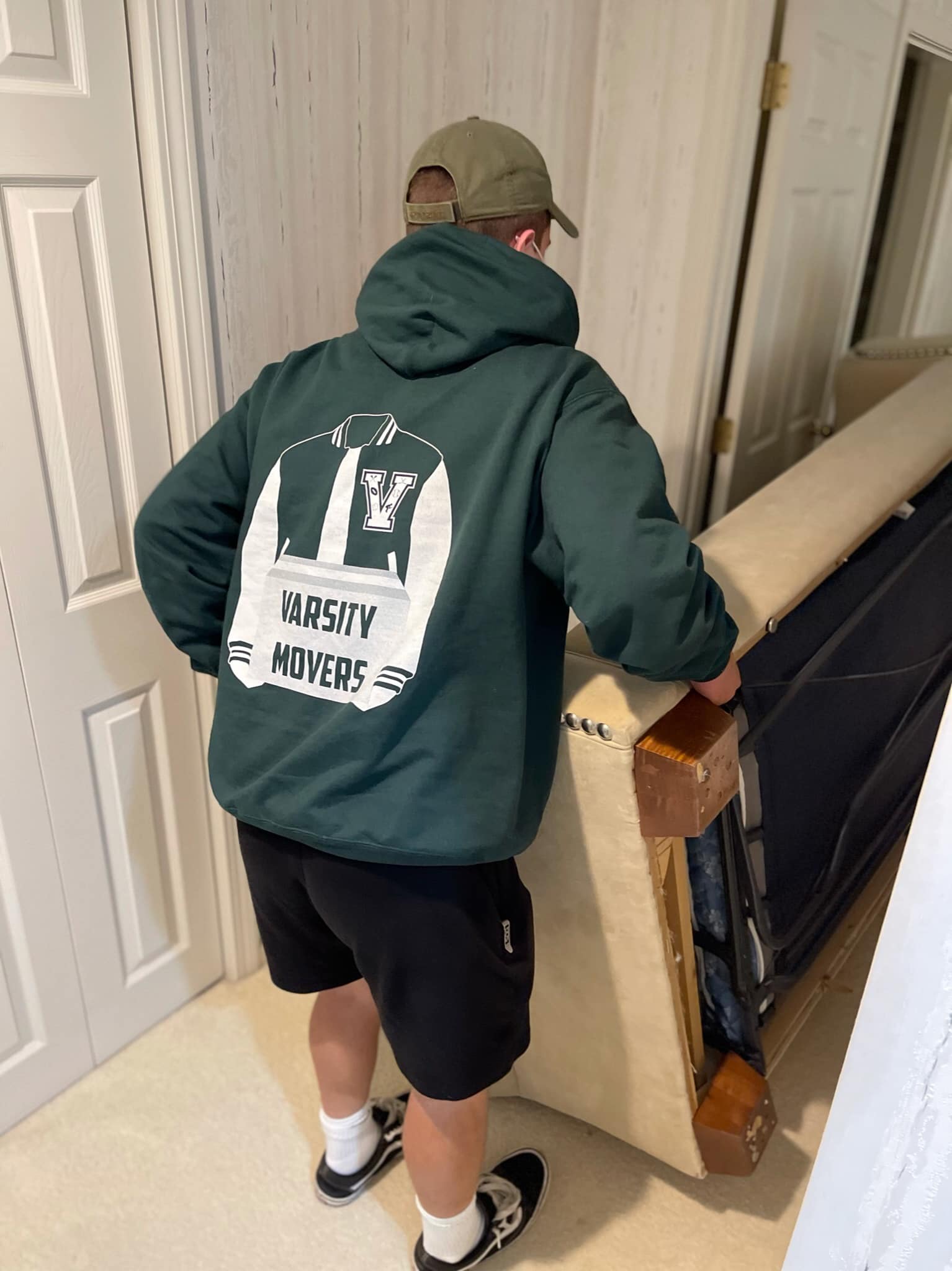 An image of A worker from Varsity Movers carrying a couch.